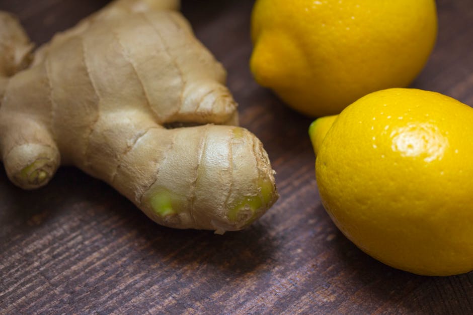 Close-up of fresh ginger root and lemons on a wooden surface showcasing natural ingredients.